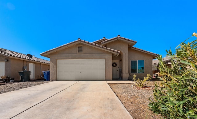4841 W 10th Pl, Yuma, AZ 85364 - mediterranean / spanish house featuring an attached garage, driveway, stucco siding, and a tile roof