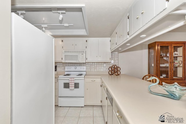 2901 S Palo Verde Ln # 38, Yuma, AZ 85364 - kitchen with white appliances, light tile patterned floors, tasteful backsplash, light countertops, and white cabinetry