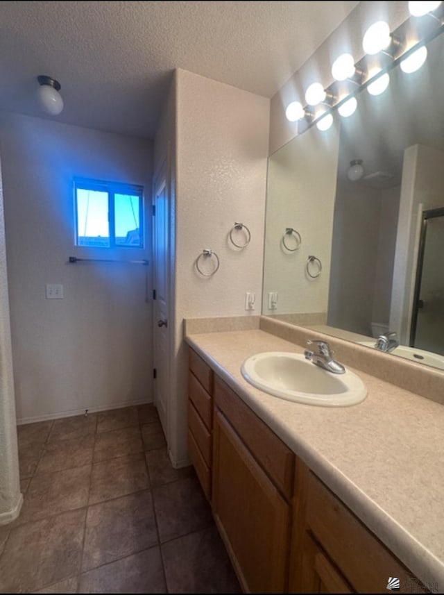 11144 E 26th Pl, Yuma, AZ 85367 - bathroom featuring vanity, a textured ceiling, a shower with door, and tile patterned flooring
