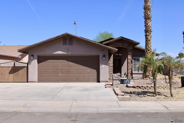single story home with an attached garage, driveway, stone siding, and stucco siding