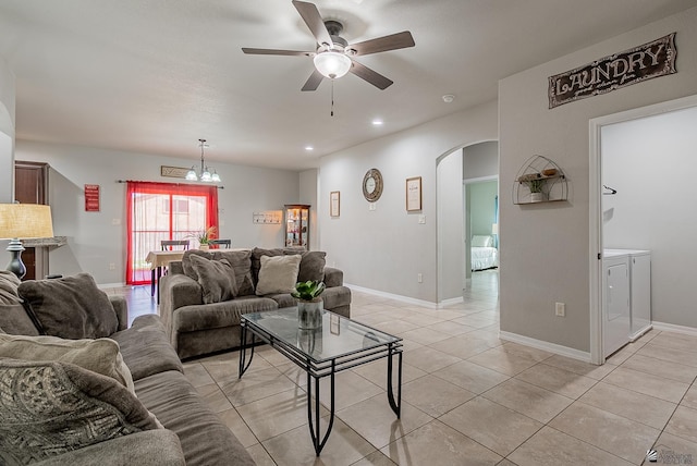 living area featuring separate washer and dryer, arched walkways, ceiling fan with notable chandelier, recessed lighting, and light tile patterned floors