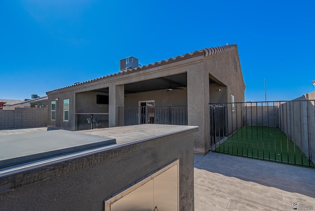 exterior space with central AC, stucco siding, a fenced backyard, a patio area, and a ceiling fan