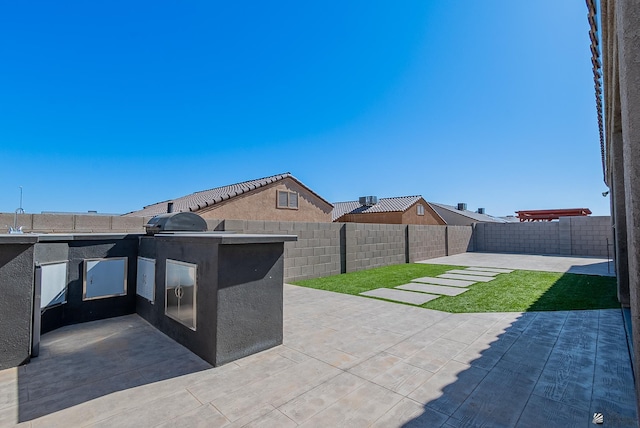 view of patio featuring a fenced backyard and an outdoor kitchen