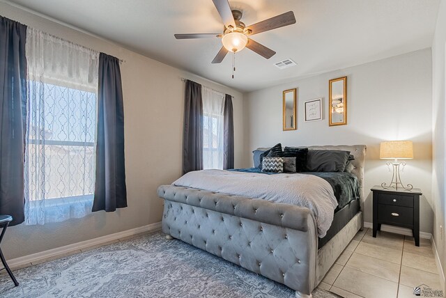 bedroom with a ceiling fan, baseboards, visible vents, and light tile patterned flooring