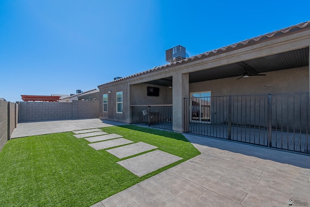 view of yard featuring a fenced backyard, ceiling fan, cooling unit, and a patio area