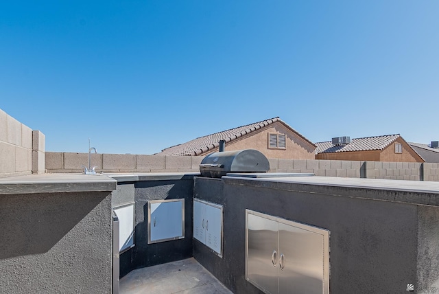 view of patio with an outdoor kitchen and fence