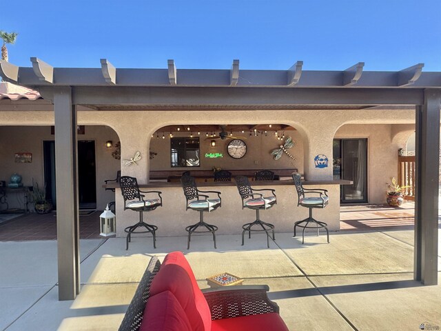 view of patio with ceiling fan and exterior bar