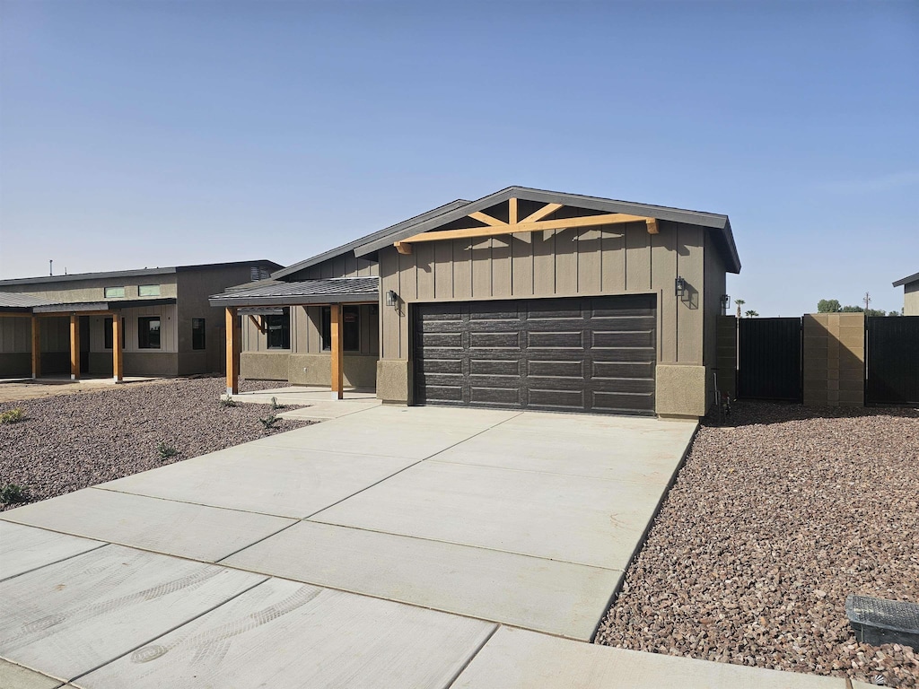 view of front facade featuring fence, a gate, an attached garage, and concrete driveway