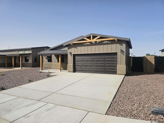 view of front facade featuring fence, a gate, an attached garage, and concrete driveway