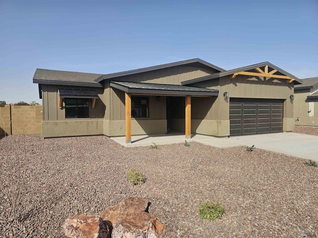view of front facade with concrete driveway, fence, a porch, and a garage