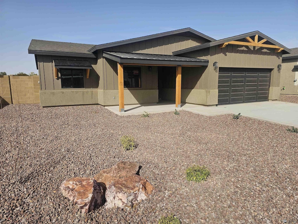 view of front of property with fence, an attached garage, and driveway