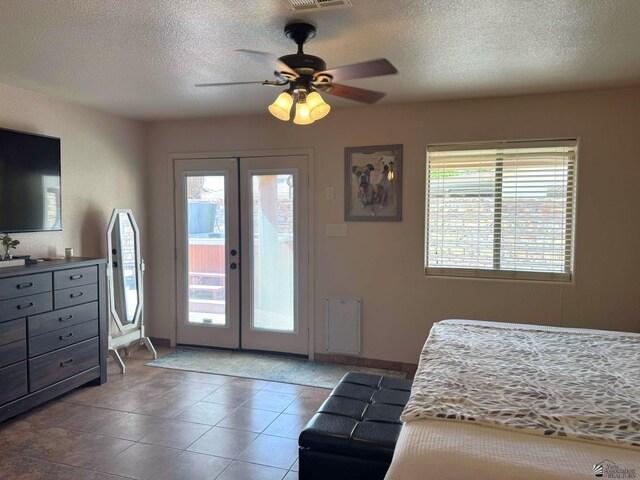 14551 E 49th St, Yuma, AZ 85367 - tiled bedroom featuring access to outside, a textured ceiling, a ceiling fan, and french doors