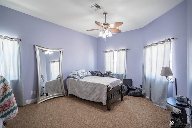 bedroom featuring light colored carpet, ceiling fan, visible vents, and multiple windows