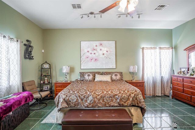 bedroom featuring dark tile patterned flooring, ceiling fan, and visible vents