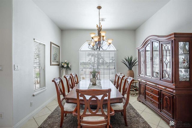 dining area featuring baseboards, visible vents, light tile patterned flooring, and a chandelier
