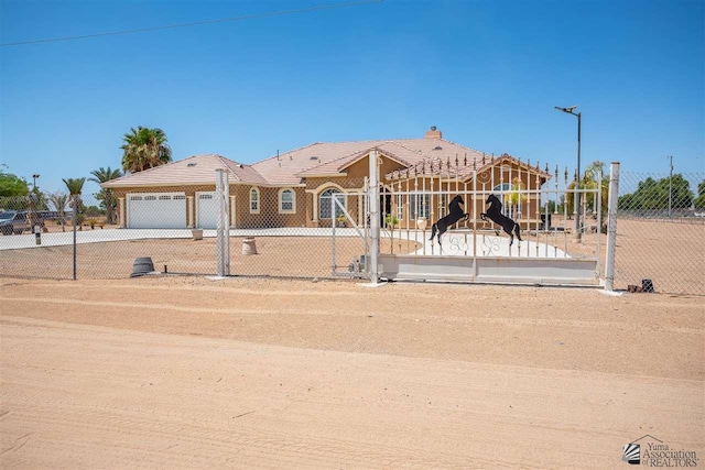 view of front of home featuring a gate, an attached garage, fence private yard, and driveway