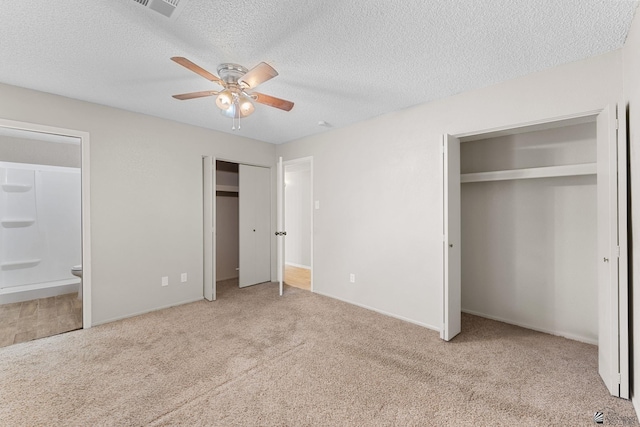 2213 W Pueblo St, Yuma, AZ 85364 - unfurnished bedroom featuring two closets, carpet floors, ensuite bath, a textured ceiling, and baseboards