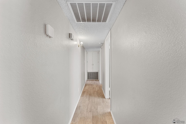 2213 W Pueblo St, Yuma, AZ 85364 - hallway with light wood-style flooring, a textured wall, baseboards, and a textured ceiling