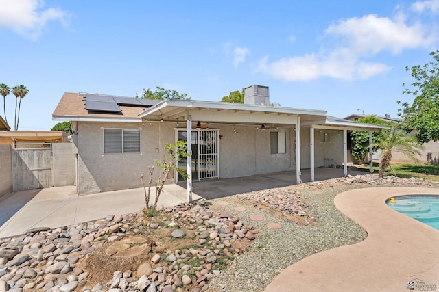 2213 W Pueblo St, Yuma, AZ 85364 - back of house with ceiling fan, roof mounted solar panels, stucco siding, a patio area, and a gate