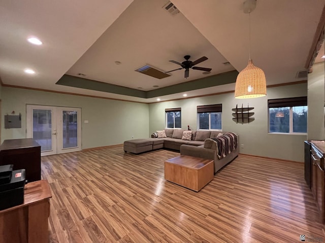 living room featuring french doors, hardwood / wood-style flooring, ceiling fan, and a tray ceiling