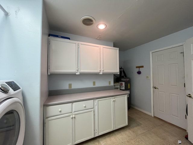 laundry area with washer / clothes dryer, light tile patterned floors, and cabinets