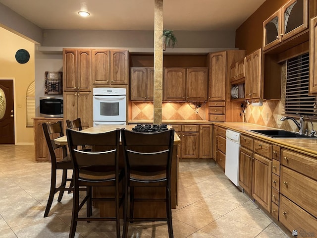 kitchen with decorative backsplash, white appliances, sink, and light tile patterned floors