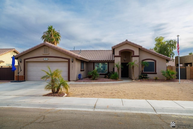 view of front of home featuring fence, an attached garage, driveway, and stucco siding