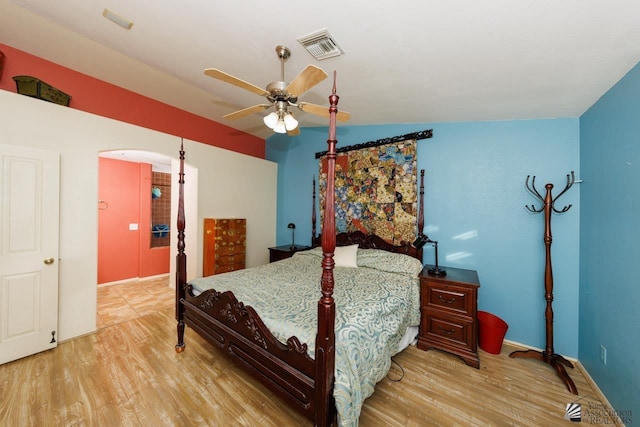 bedroom featuring baseboards, a ceiling fan, wood finished floors, and visible vents
