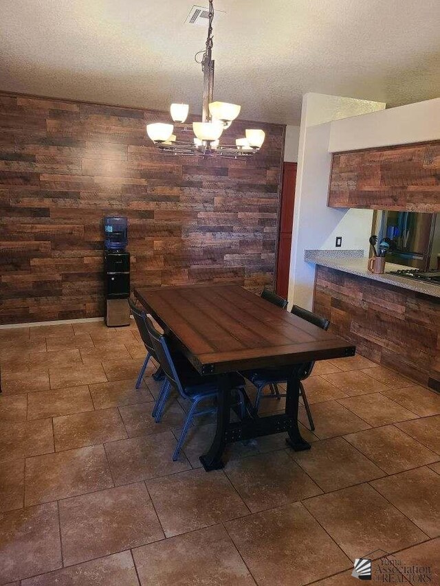 6311 E 42nd St, Yuma, AZ 85365 - dining room featuring wooden walls, a chandelier, and a textured ceiling