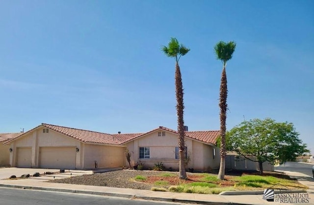 6311 E 42nd St, Yuma, AZ 85365 - mediterranean / spanish home featuring an attached garage, a tile roof, and stucco siding