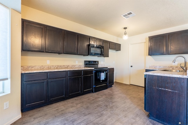 7959 E 43rd Pl, Yuma, AZ 85365 - kitchen with light wood-type flooring, a sink, black appliances, and visible vents