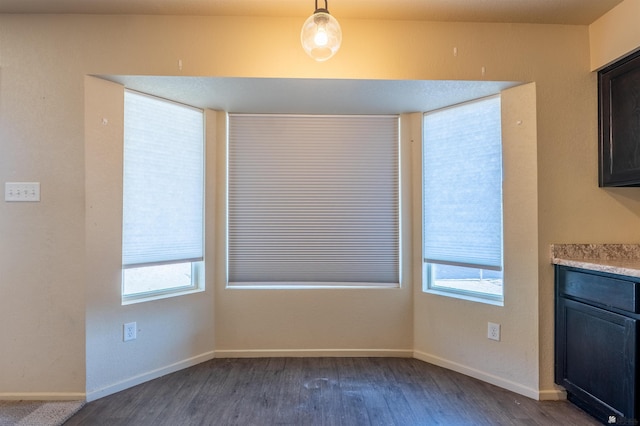 7959 E 43rd Pl, Yuma, AZ 85365 - unfurnished dining area featuring baseboards, dark wood-style floors, and a healthy amount of sunlight