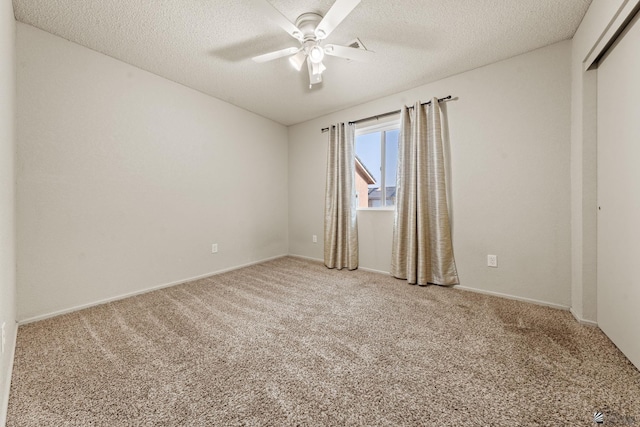 empty room featuring a ceiling fan, a textured ceiling, light carpet, and baseboards
