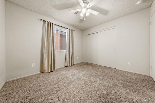 unfurnished bedroom featuring carpet floors, a textured ceiling, ceiling fan, and a closet