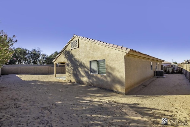 view of side of property with a fenced backyard, stucco siding, and a patio area