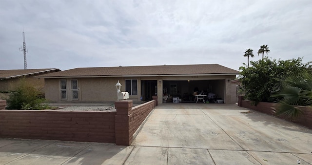 ranch-style house featuring driveway, a garage, and stucco siding