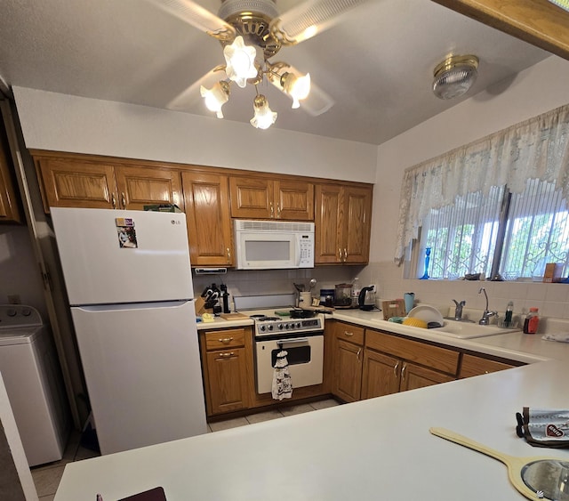 kitchen with washer / clothes dryer, white appliances, brown cabinetry, and tasteful backsplash