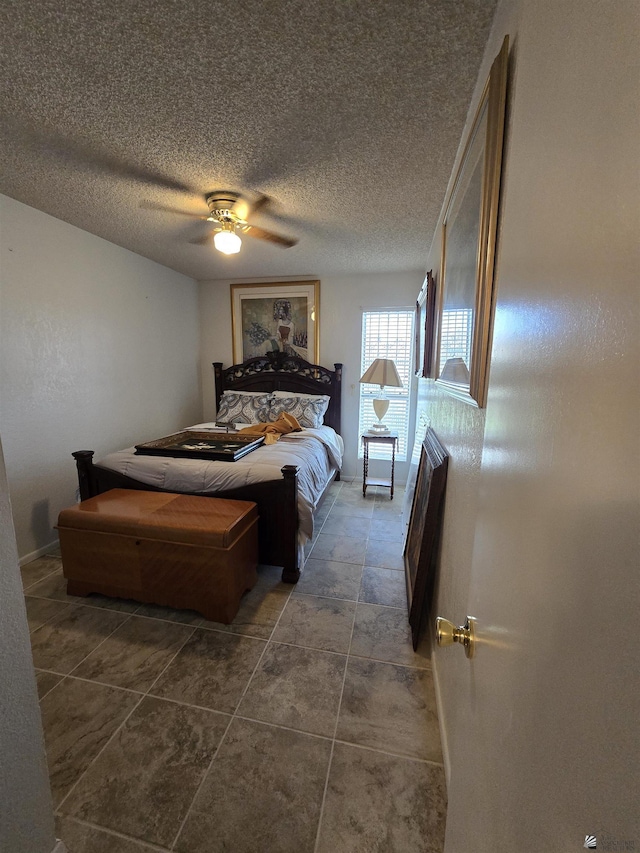 bedroom with a ceiling fan and a textured ceiling