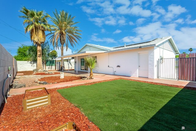 541 E Hacienda Dr, Yuma, AZ 85365 - rear view of property featuring roof mounted solar panels and a patio area