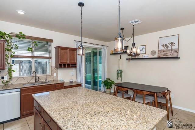 6588 E 35th Pl, Yuma, AZ 85365 - kitchen with dishwasher, light tile patterned flooring, a kitchen island, decorative light fixtures, and tasteful backsplash