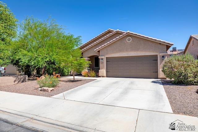 6588 E 35th Pl, Yuma, AZ 85365 - view of front of home with stucco siding, a garage, concrete driveway, and a tile roof