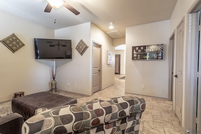 bedroom featuring baseboards, arched walkways, visible vents, and stone tile flooring