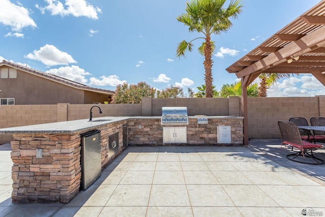 view of patio featuring grilling area, fence, area for grilling, a pergola, and a sink