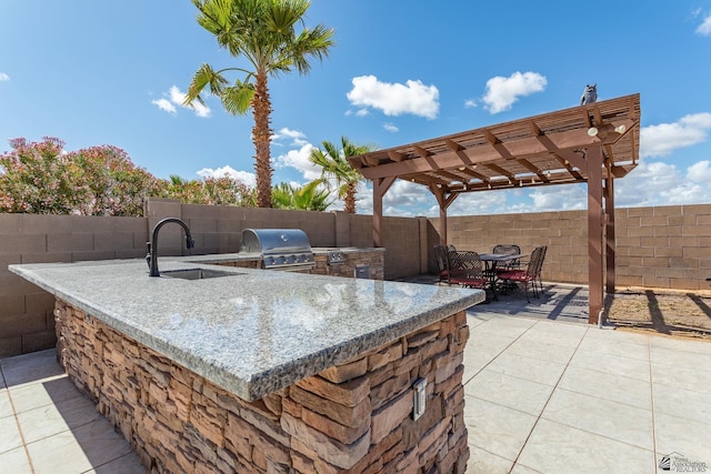 view of patio with grilling area, exterior kitchen, and a fenced backyard