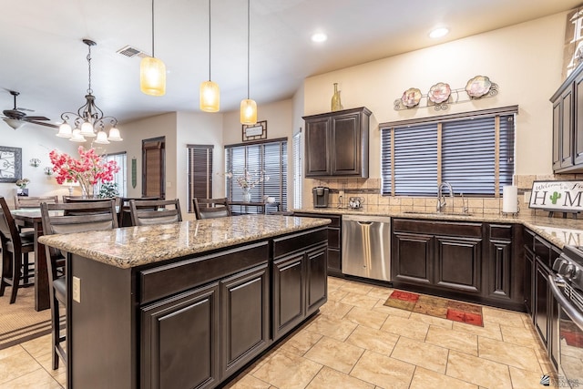 kitchen featuring visible vents, a sink, backsplash, a center island, and stainless steel appliances