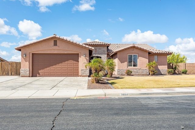 mediterranean / spanish-style house with stone siding, stucco siding, driveway, and fence