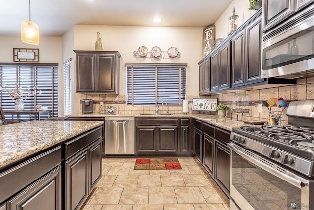 kitchen featuring a sink, dark brown cabinetry, tasteful backsplash, and stainless steel appliances