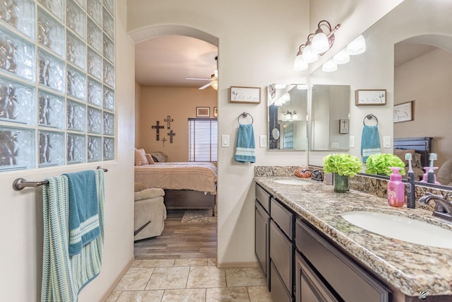 bathroom featuring a sink, a ceiling fan, double vanity, and ensuite bathroom