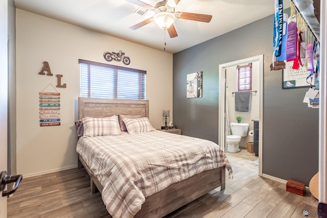 bedroom featuring visible vents, ceiling fan, baseboards, ensuite bathroom, and light wood-style floors