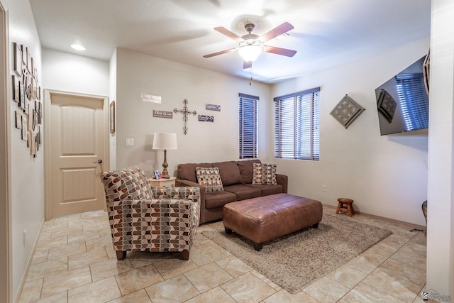 living room with a ceiling fan and baseboards